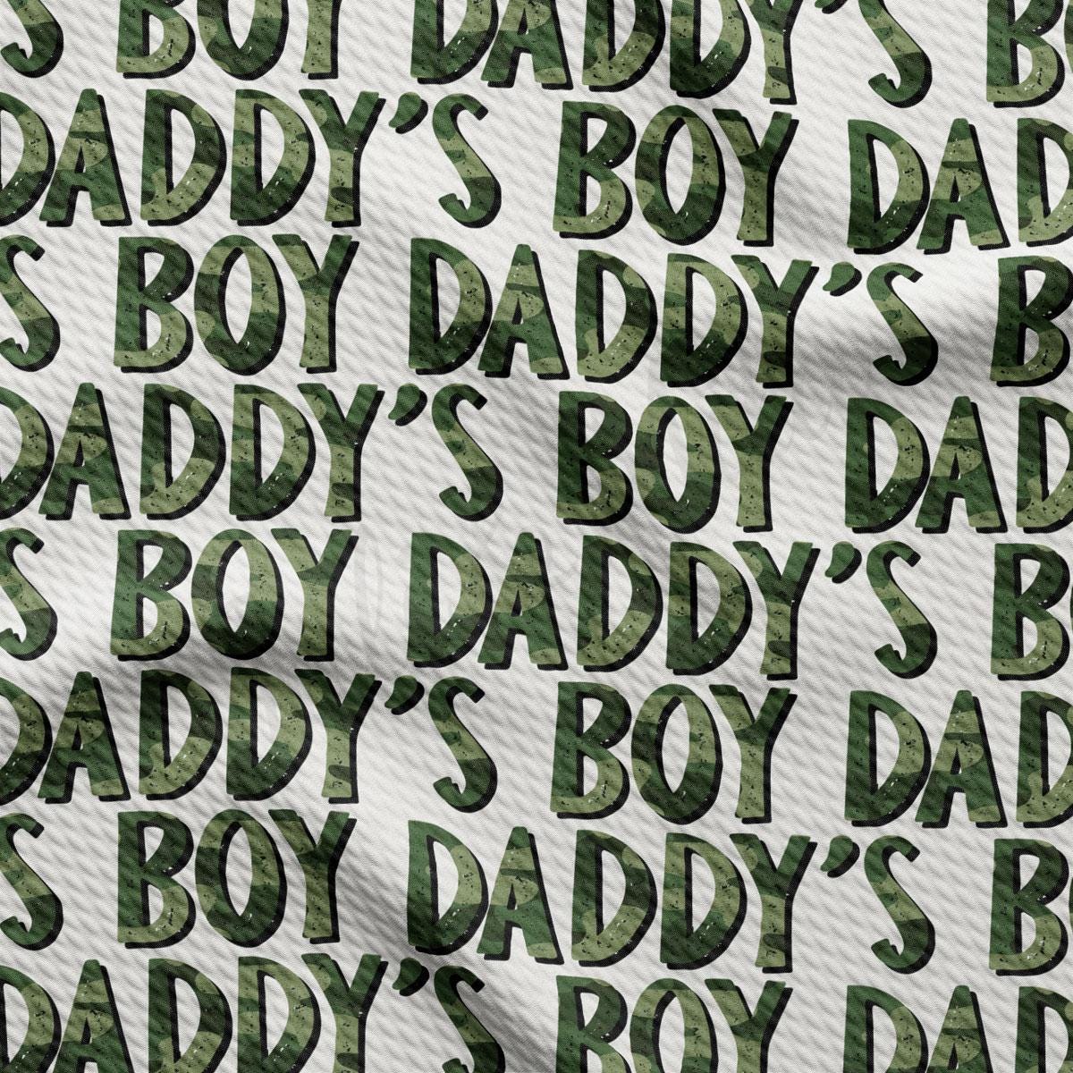 a green camouflage print fabric with the words daddy's boy's