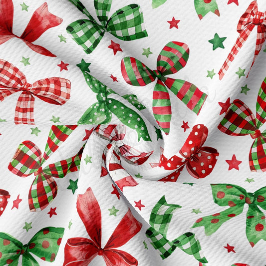 a close-up view of a fabric with a repeating pattern of red and green bows, along with stars and polka dots, creating a festive and holiday-themed design.