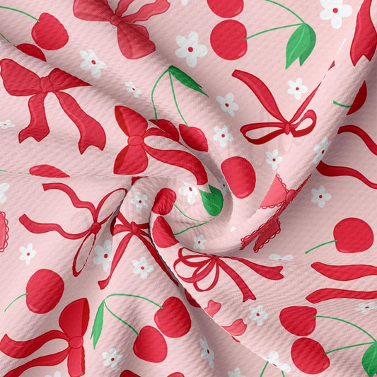 a close up of a pink fabric with cherries on it