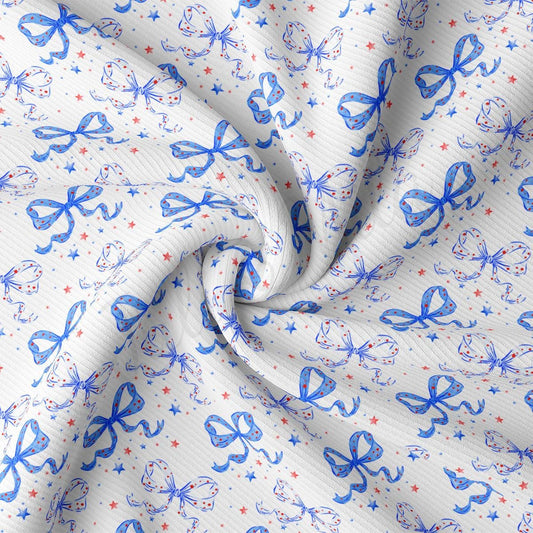 a close up of a white fabric with blue and red bows