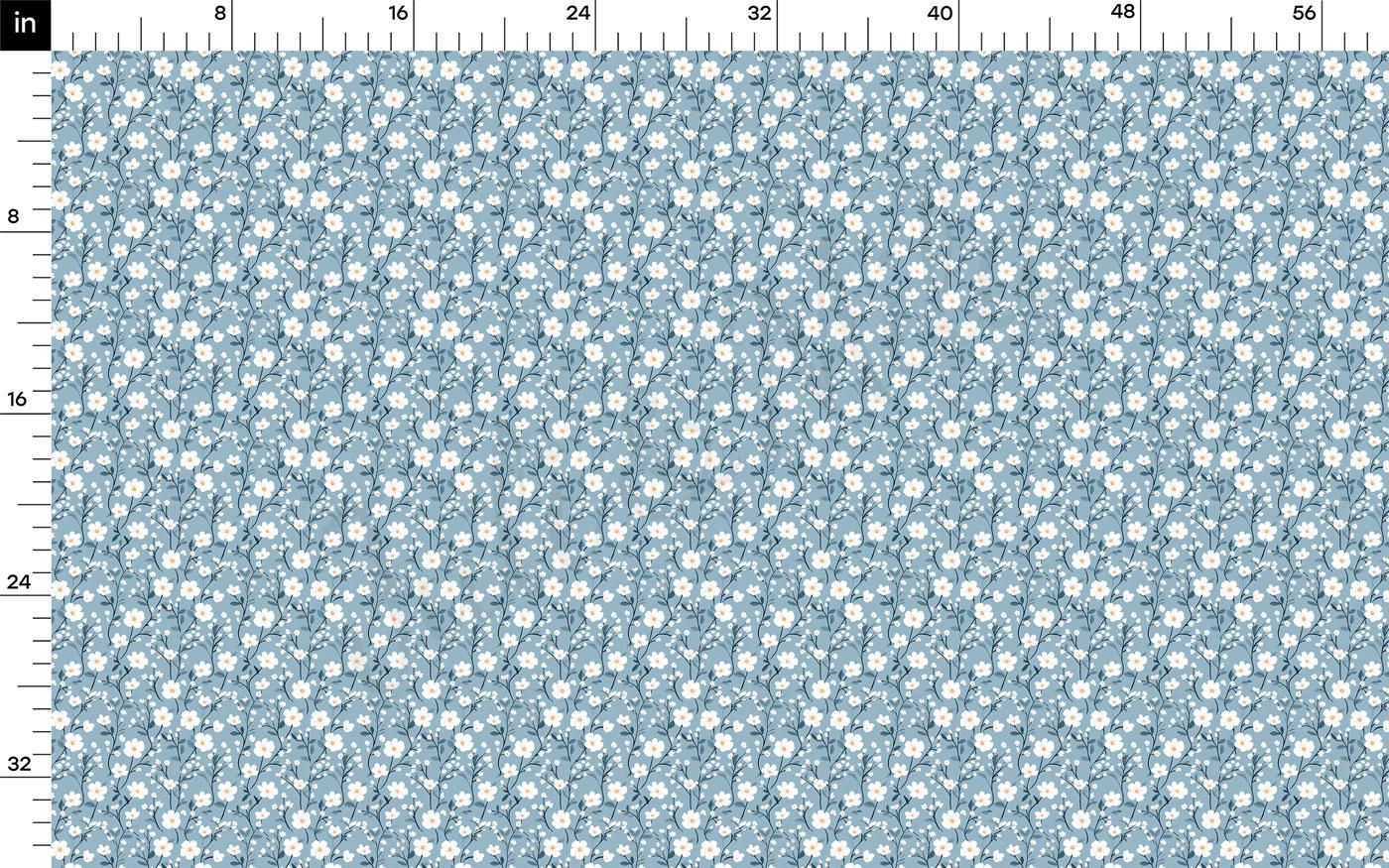 The image is a fabric print with a repeating pattern of small white flowers or dots on a light blue background. The print is designed to be used as a textile or material, and it appears to be a simple, minimalist design.