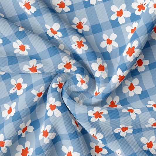 a blue and white checkered fabric with red and white flowers