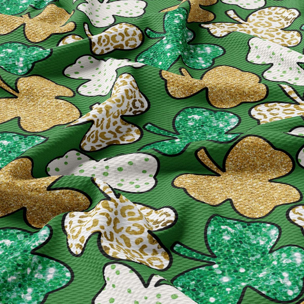 a close up of a green and gold fabric with shamrocks