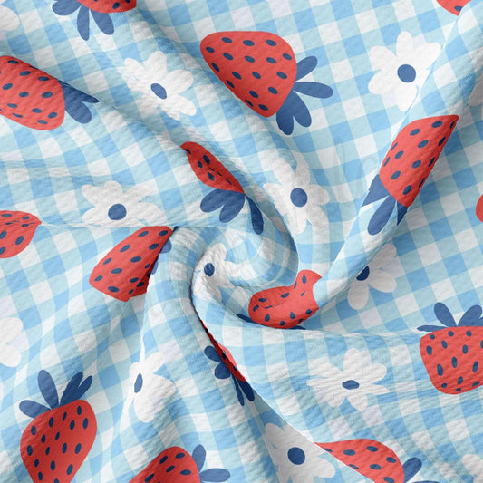 a blue and white checkered fabric with strawberries on it