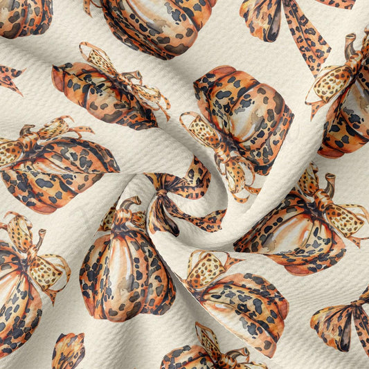 a close-up view of a fabric with a repeating pattern of leopard print pumpkins and butterflies.