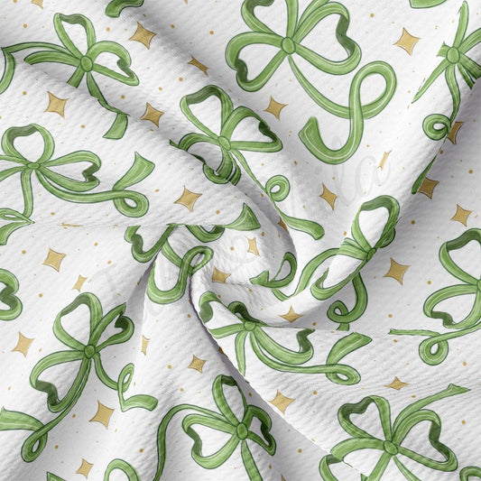 a close up of a white fabric with green bows