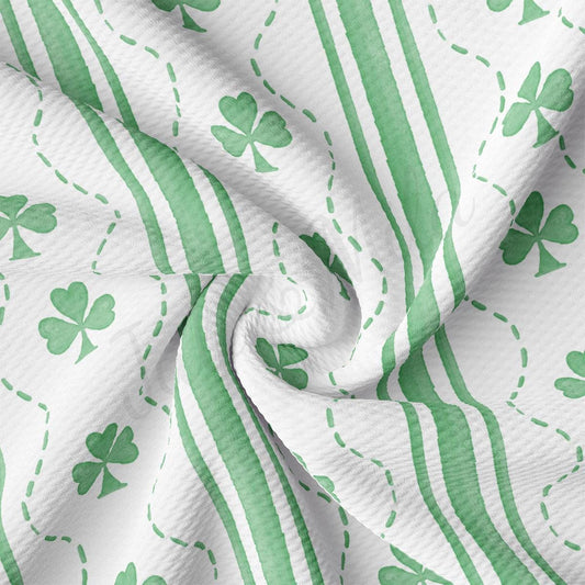 a green and white striped fabric with shamrocks on it