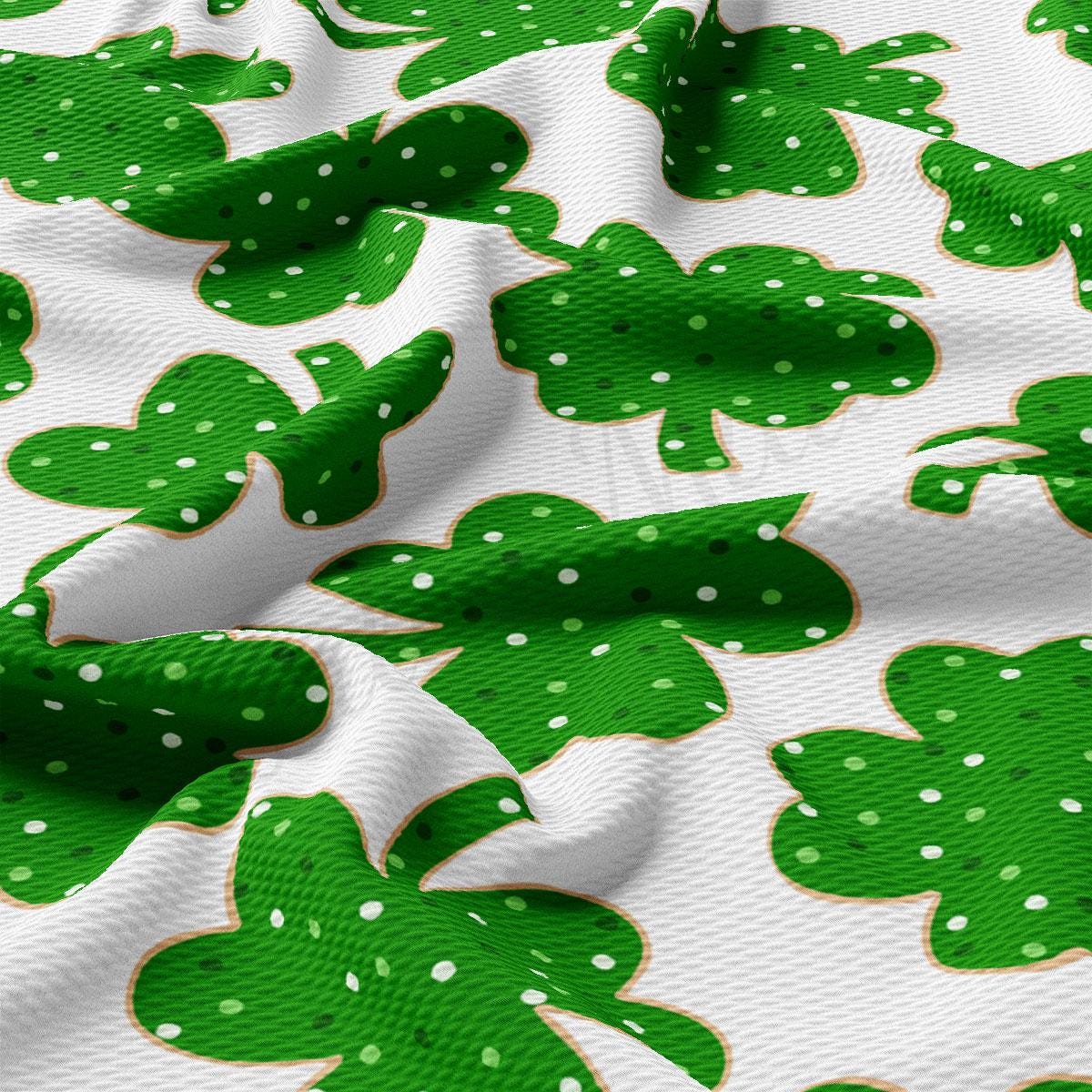 a close up of a green and white fabric with shamrocks on it