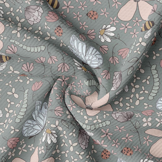 a close up of a fabric with flowers and bugs on it