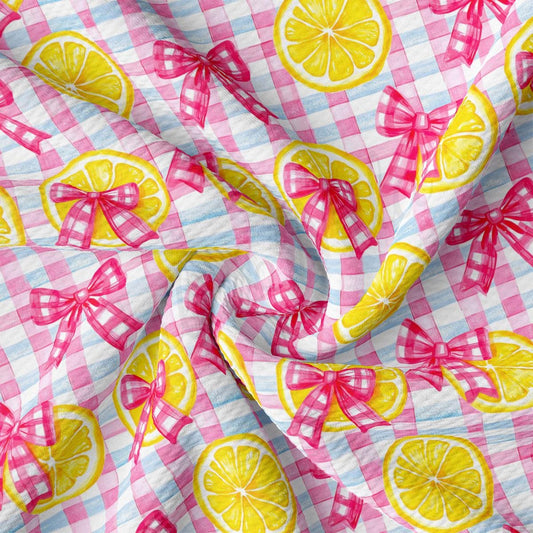 a pink and white checkered fabric with lemons on it