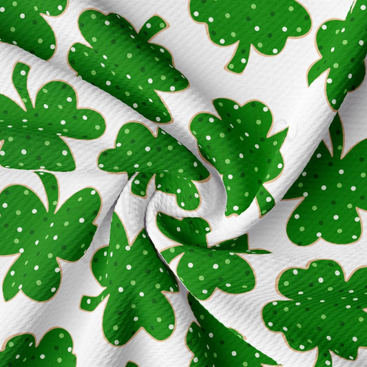 a close up of a green and white fabric with shamrocks on it