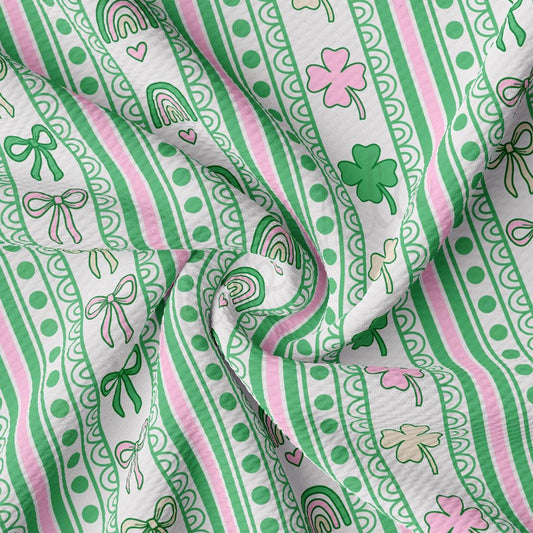 a green and pink striped fabric with shamrocks on it