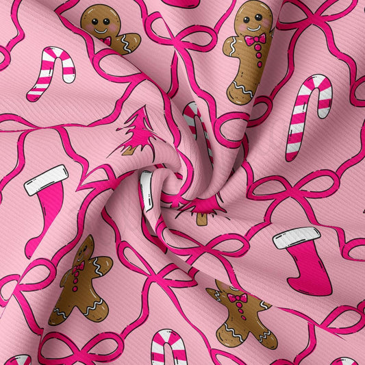 a pink fabric with a repeating pattern of gingerbread men and candy canes.