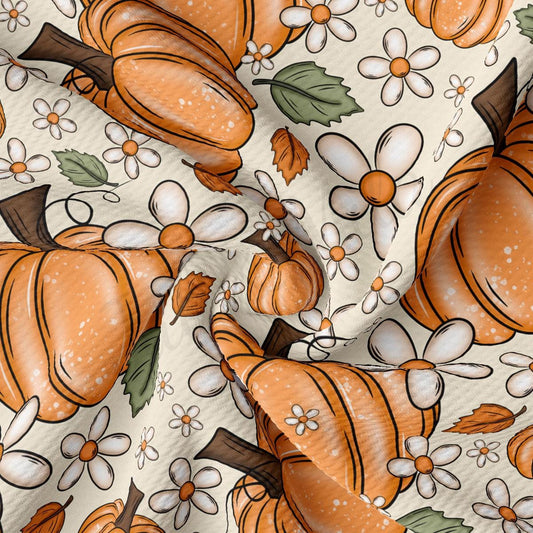 The image is a close-up of a fabric with a repeating pattern of orange pumpkins and white flowers.