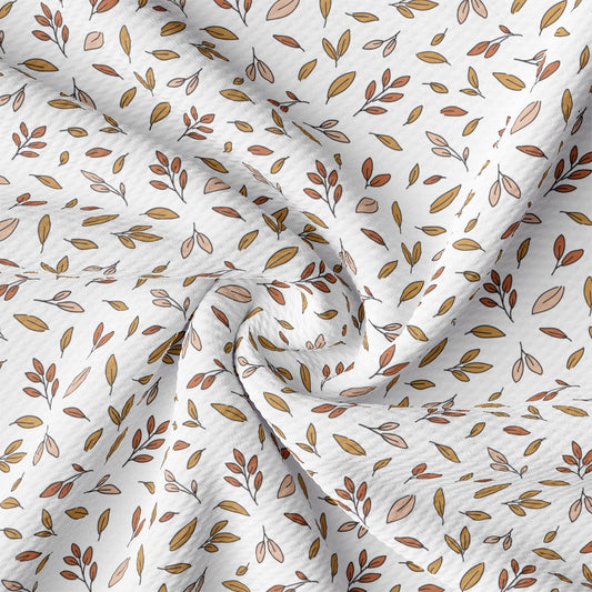 a close up of a white fabric with leaves on it