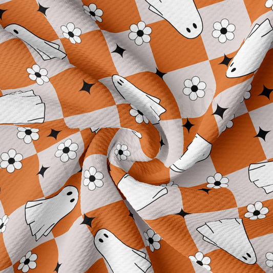 an orange and white checkered fabric with black and white flowers