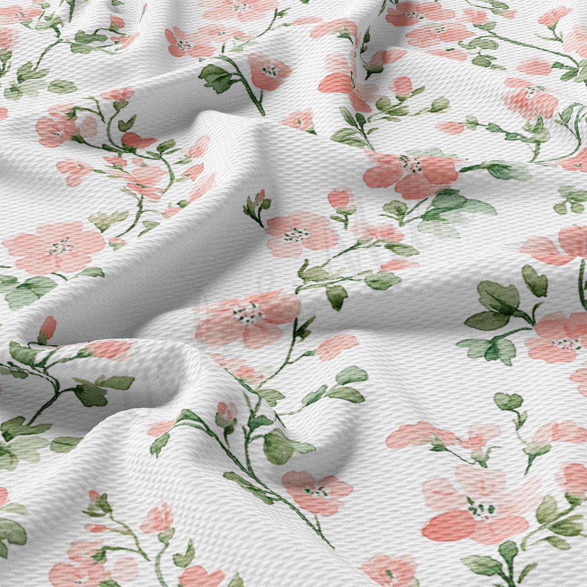 a close-up view of a fabric with a floral pattern of pink flowers and green leaves. The fabric appears to be white, and the pattern is intricate and detailed, with the flowers and leaves appearing to be hand-painted or printed onto the fabric.