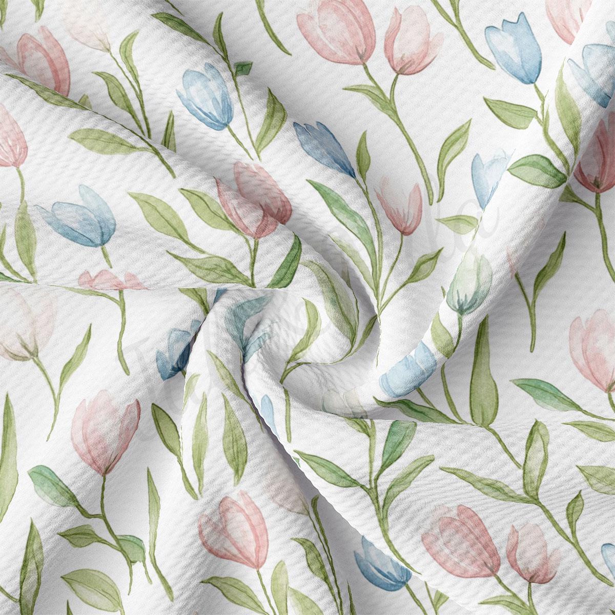 a close-up view of a fabric with a repeating floral pattern of pink, blue, and green flowers and leaves.