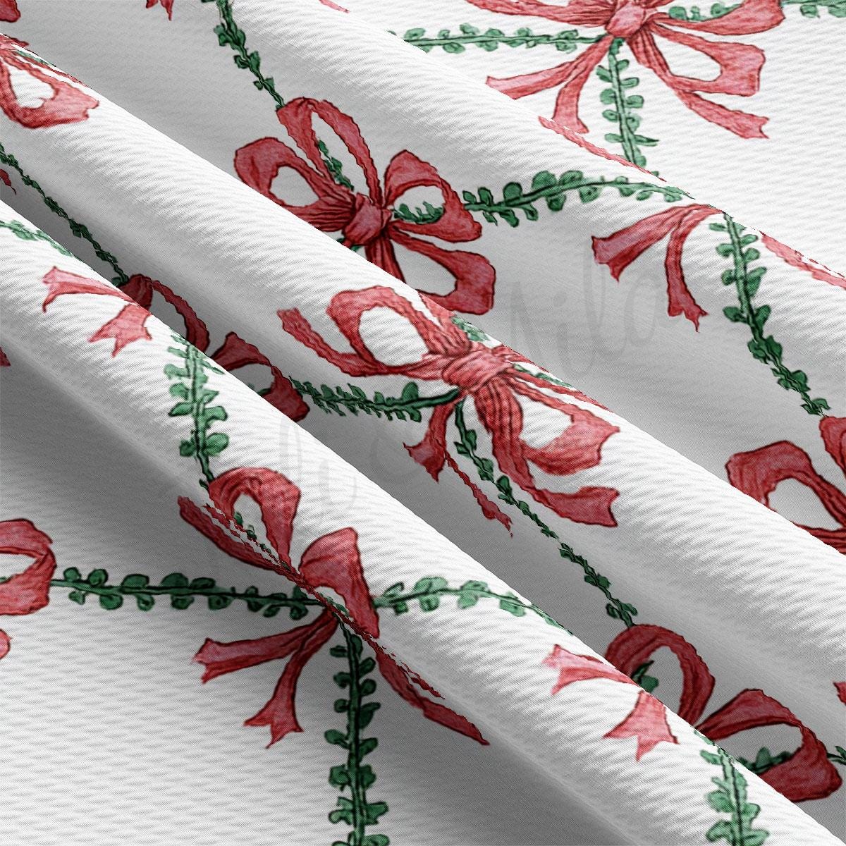 a close-up view of a fabric with a repeating pattern of red bows and green leaves. The bows are arranged in a diagonal pattern, creating a sense of movement and dynamism across the fabric. The green leaves add a touch of natural beauty to the overall design.