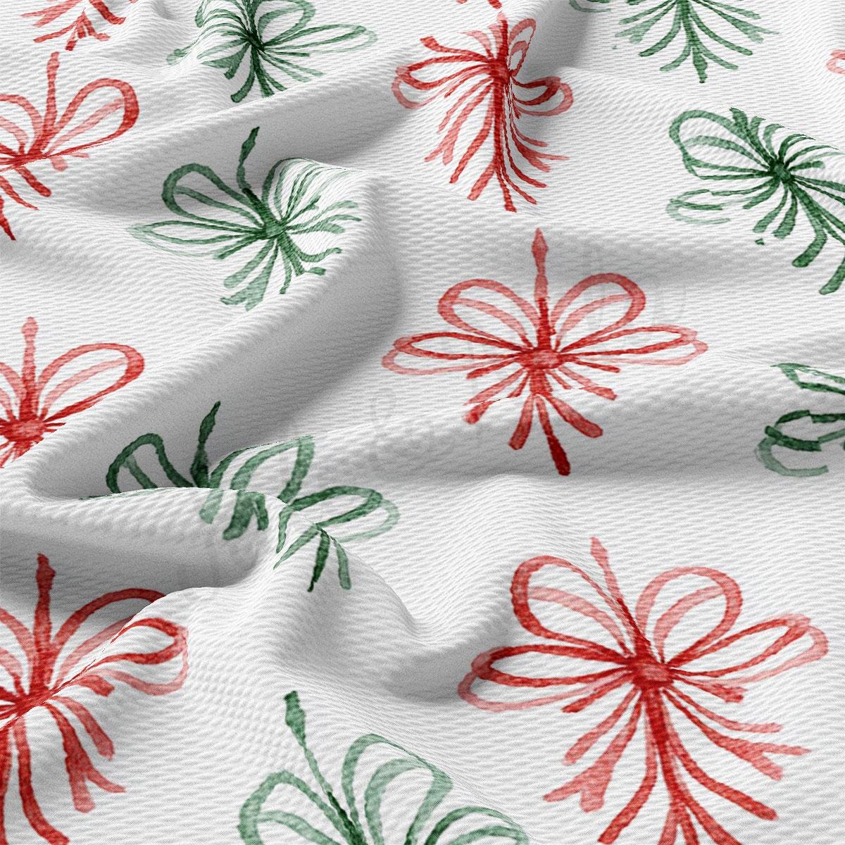 a close-up view of a fabric with a repeating pattern of red and green floral designs. The pattern consists of stylized flowers and leaves, creating a visually appealing and textured appearance.