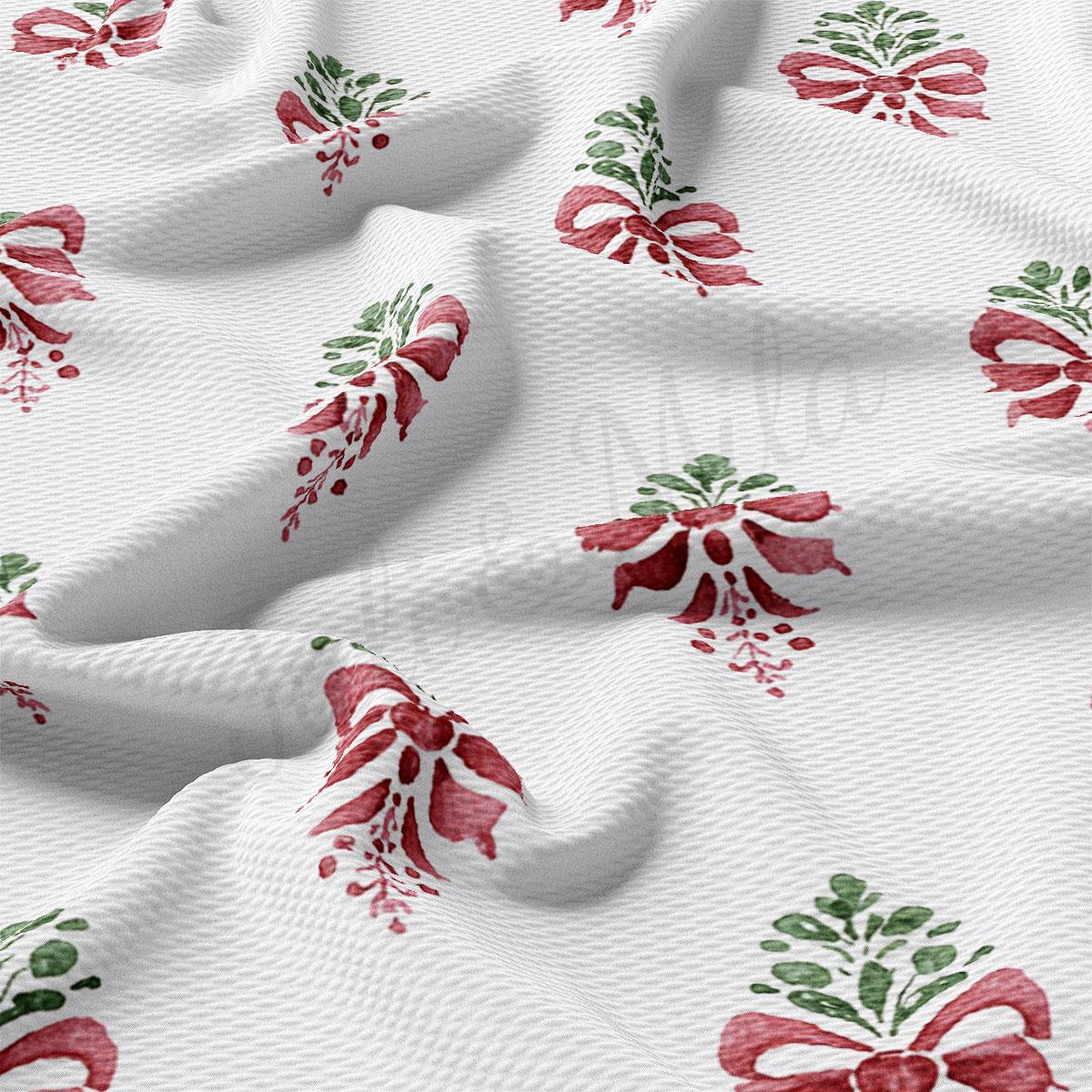 a close-up view of a white fabric with a repeating pattern of red and green floral designs, resembling a bow or ribbon.