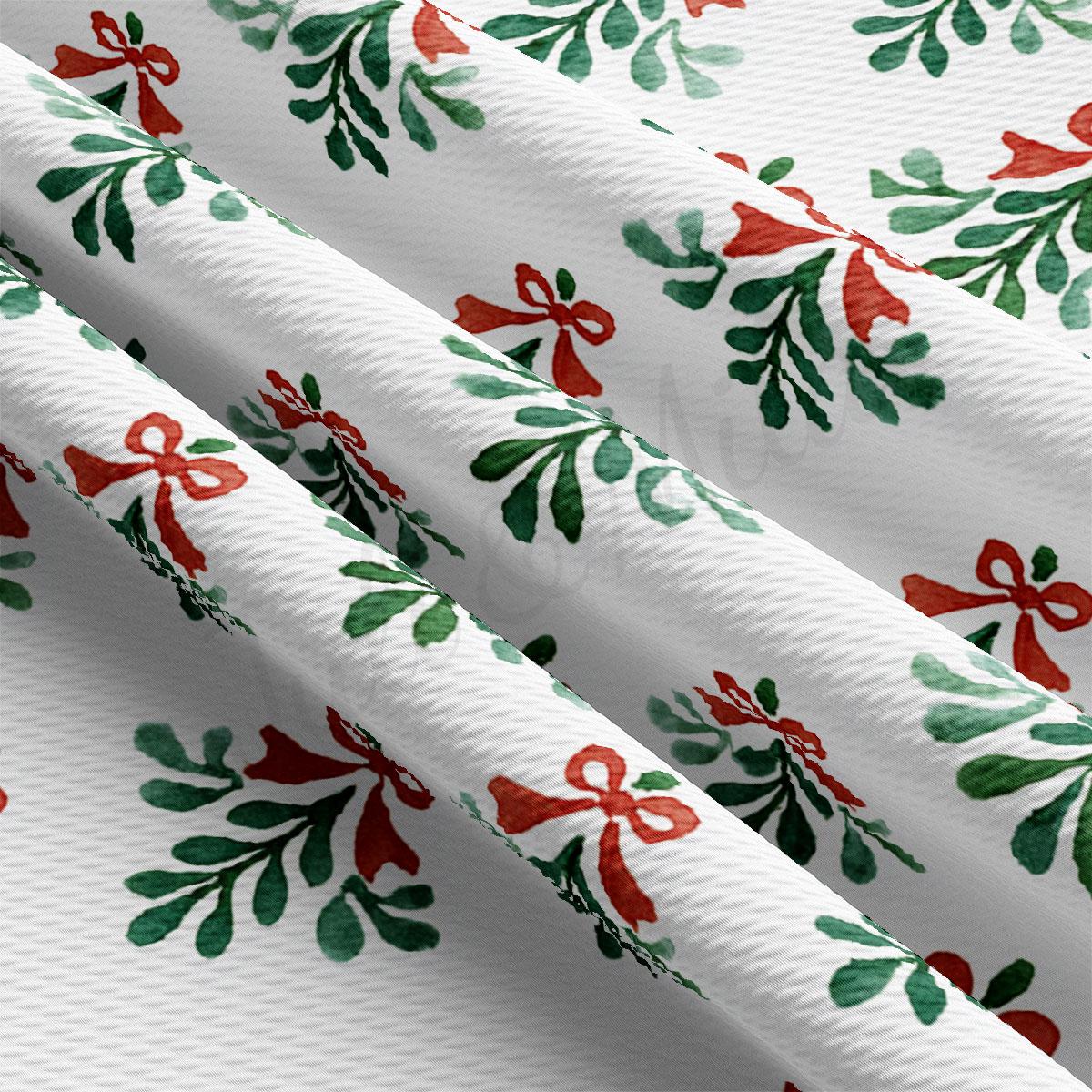 a close-up view of a fabric with a repeating pattern of green leaves and red bows.
