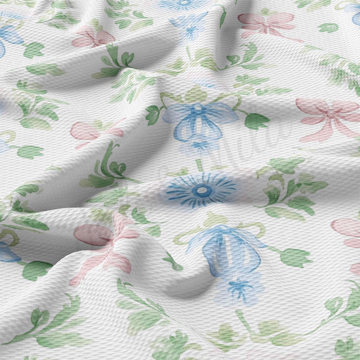 a close-up view of a fabric with a floral pattern, featuring various shades of green, pink, and blue flowers and leaves.