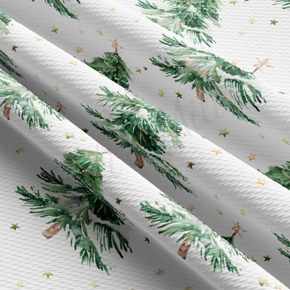 a close-up view of a fabric with a repeating pattern of green pine trees and gold stars.