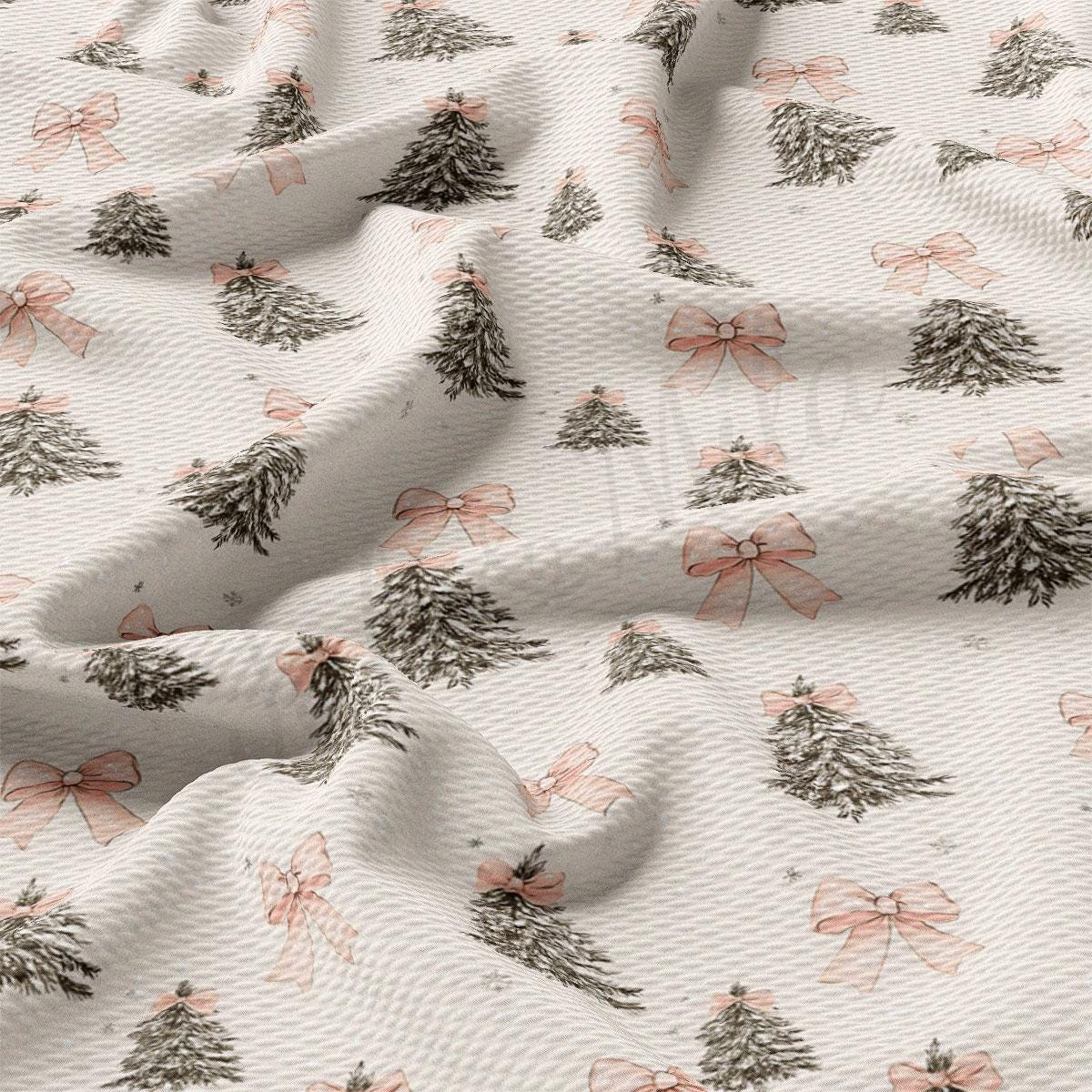 a close-up view of a fabric with a repeating pattern of Christmas trees and pink bows.