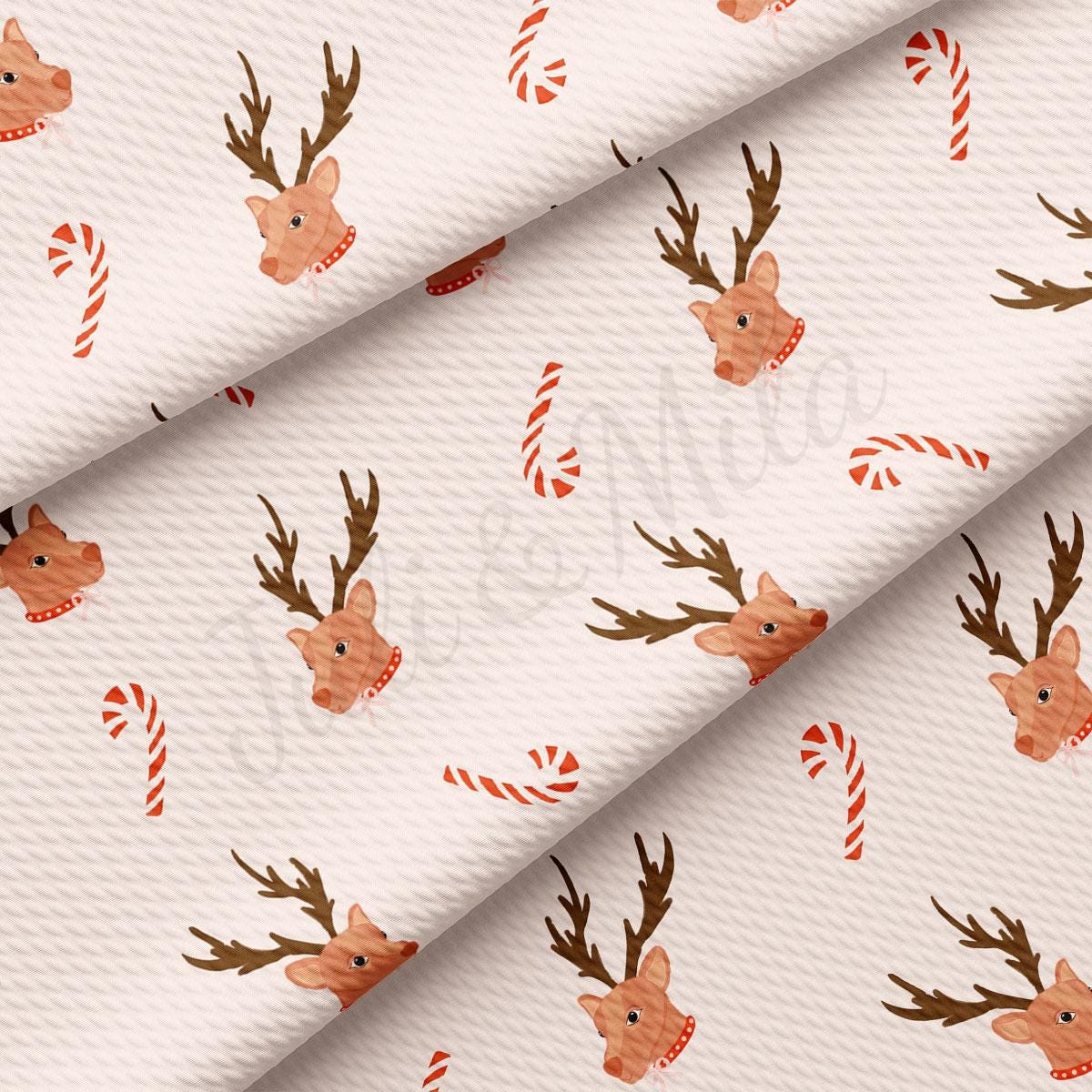 a white fabric with reindeers and candy canes on it