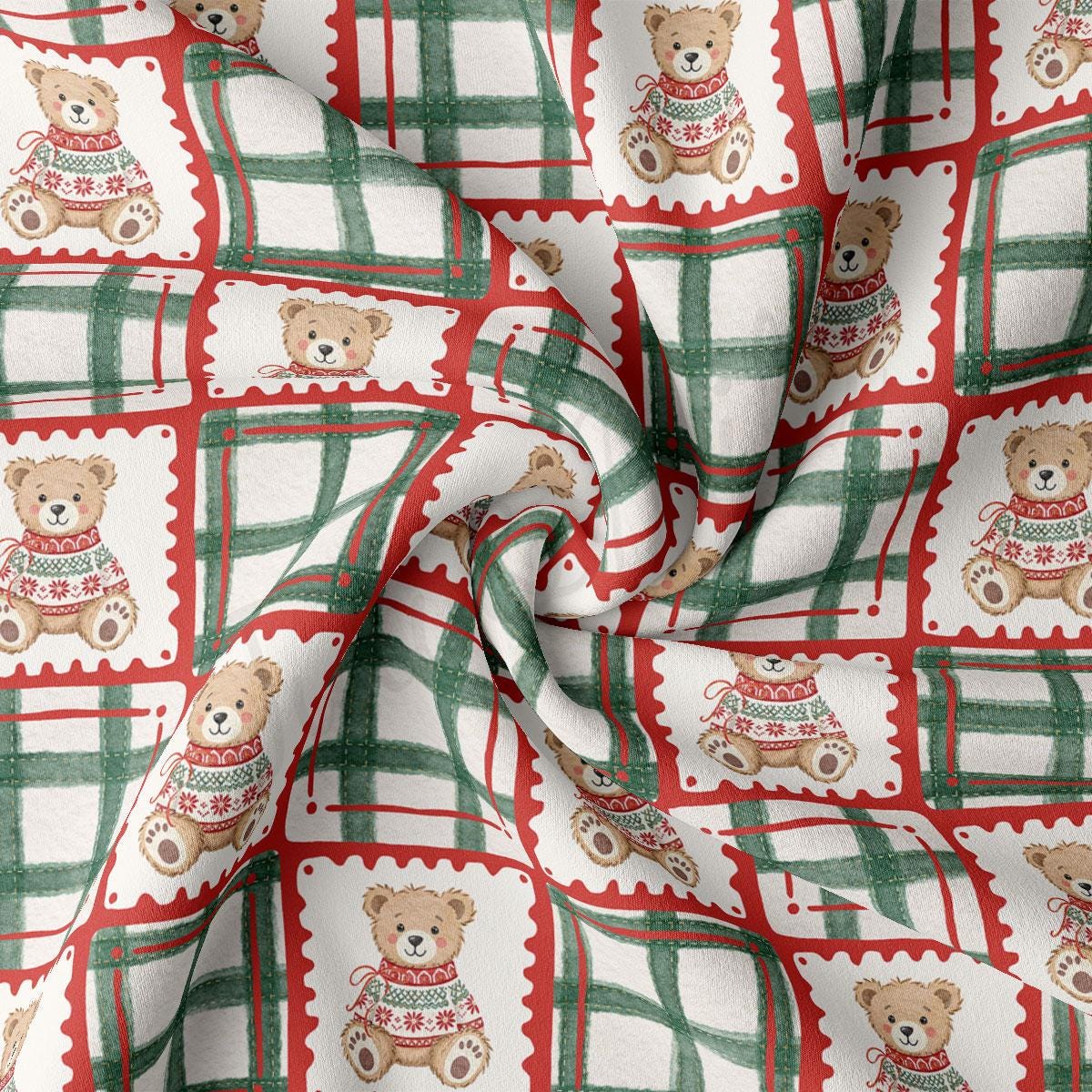 The image is a close-up of a fabric with a repeating pattern of teddy bears wearing sweaters in red and green plaid designs.