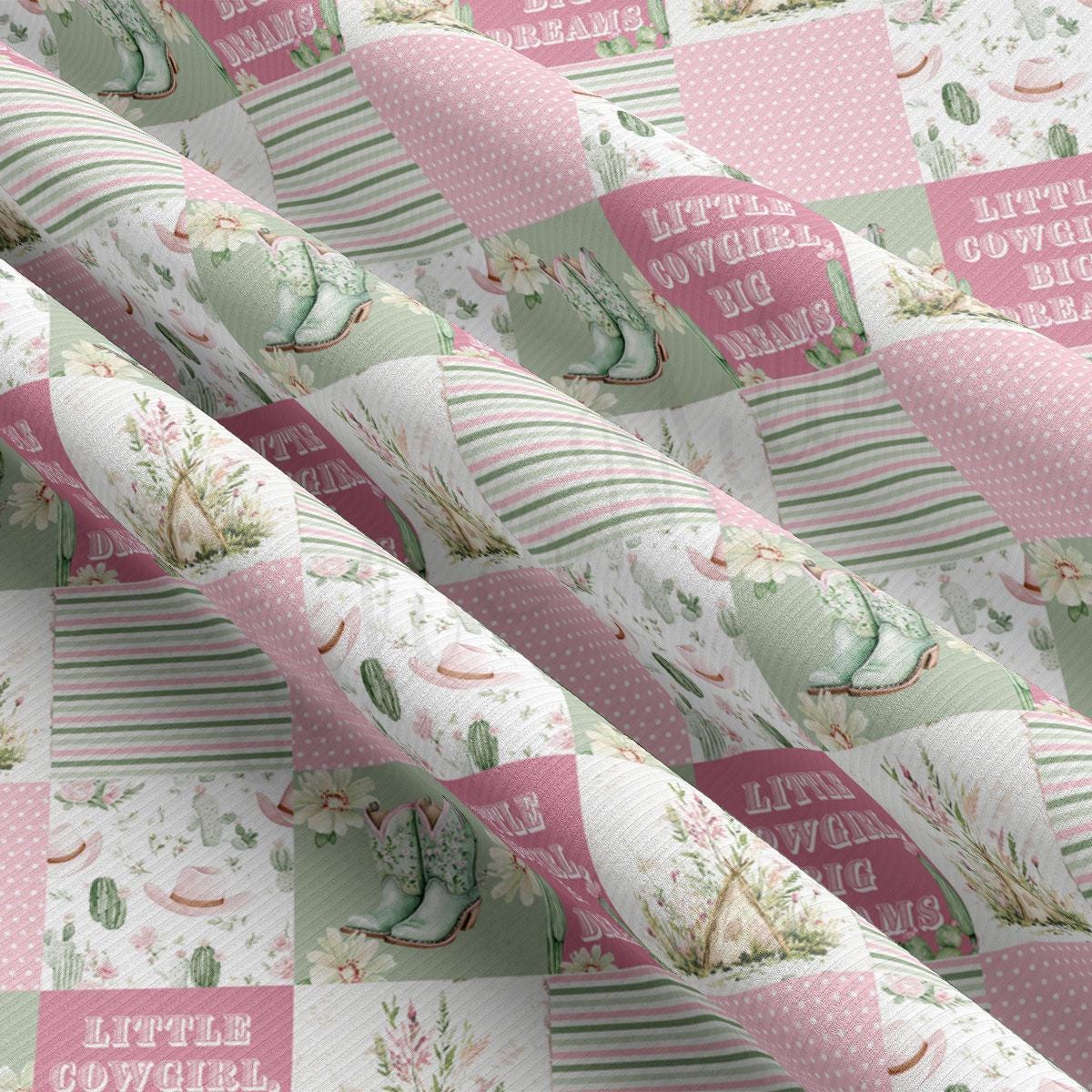 The image is a close-up of a fabric with a repeating pattern of pink and green floral and cowboy-themed designs.