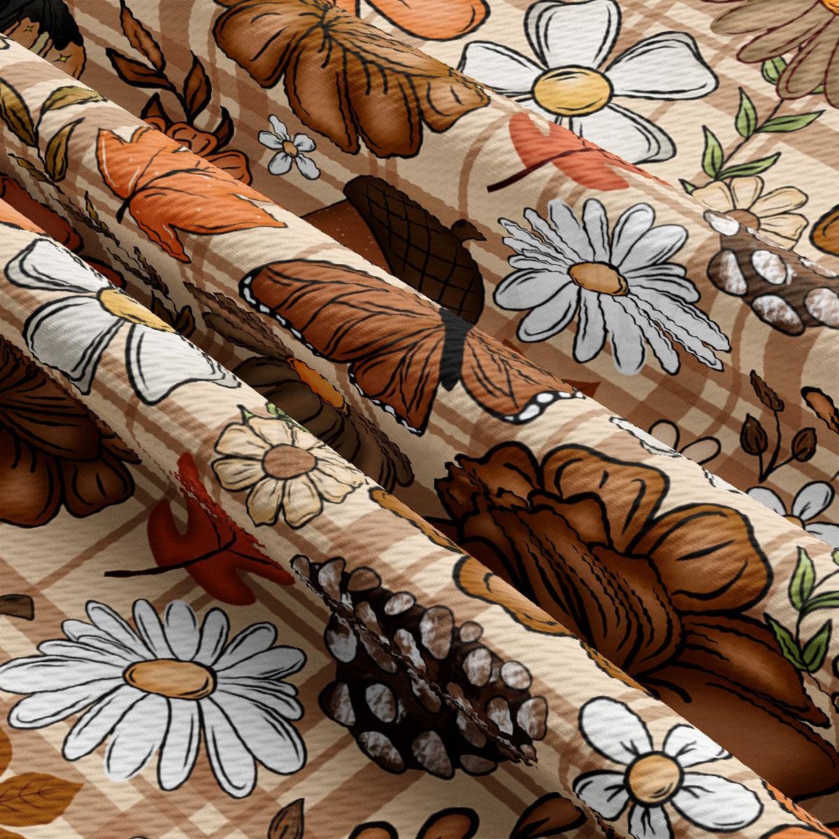 The image is a close-up view of a fabric with a repeating pattern of various flowers and leaves, including daisies, pine cones, and other natural elements. The pattern is predominantly brown and orange, with some white and green accents. The fabric appears to be made of a soft, textured material, and the arrangement of the flowers and leaves creates a visually appealing and intricate design.