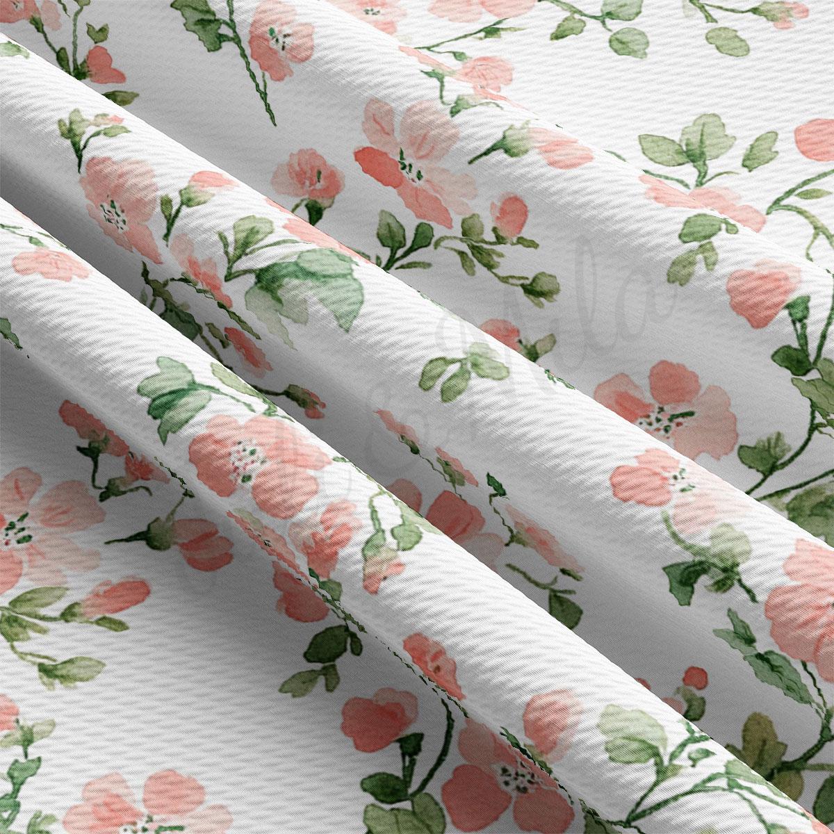 a close-up view of a fabric with a floral pattern of pink flowers and green leaves. The fabric appears to be white, and the pattern is repeating across multiple panels.