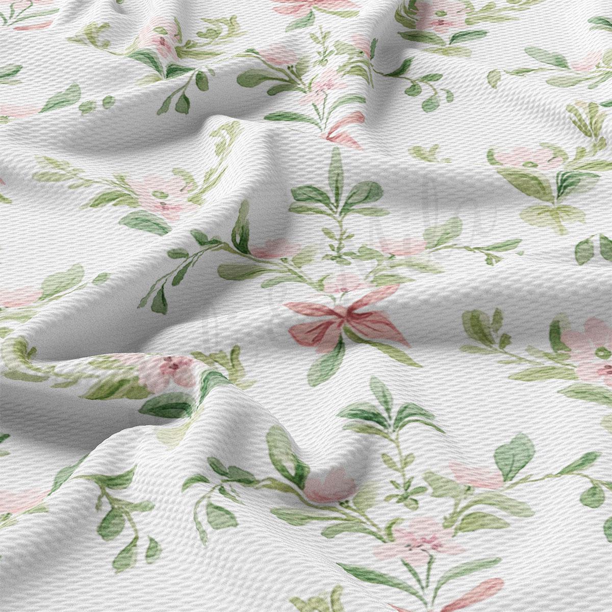a close-up view of a fabric with a floral pattern, featuring various shades of pink and green leaves and flowers. The fabric appears to be wrinkled, giving it a textured and natural appearance.