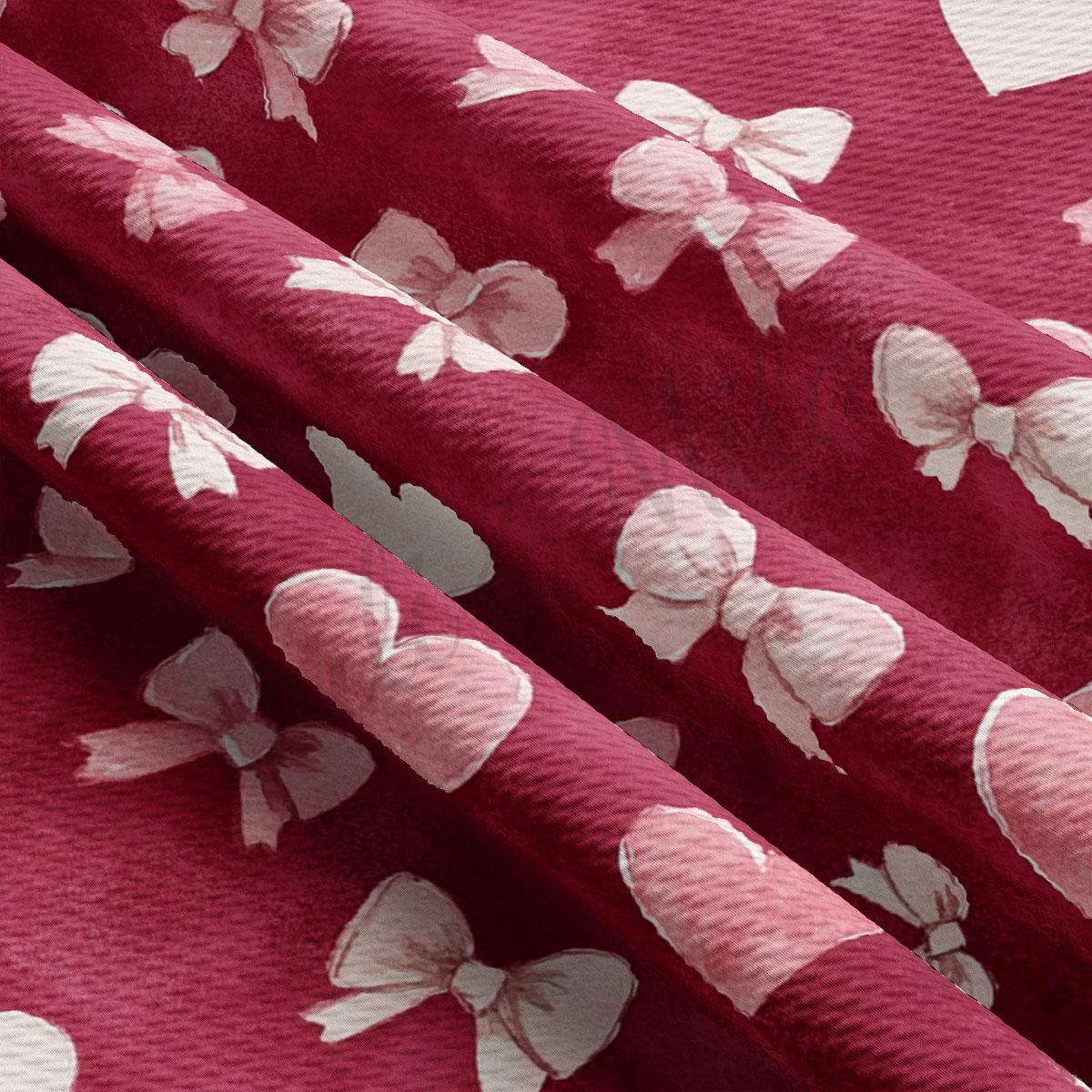 a close-up view of a fabric with a repeating pattern of pink bows on a red background.