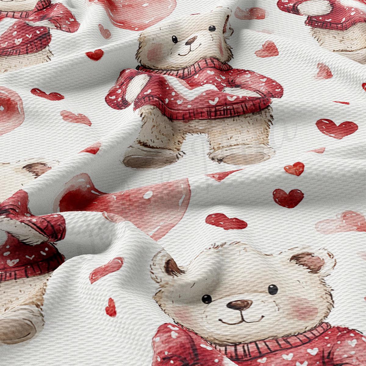 a close-up view of a fabric with a repeating pattern of teddy bears wearing red sweaters and surrounded by red hearts.