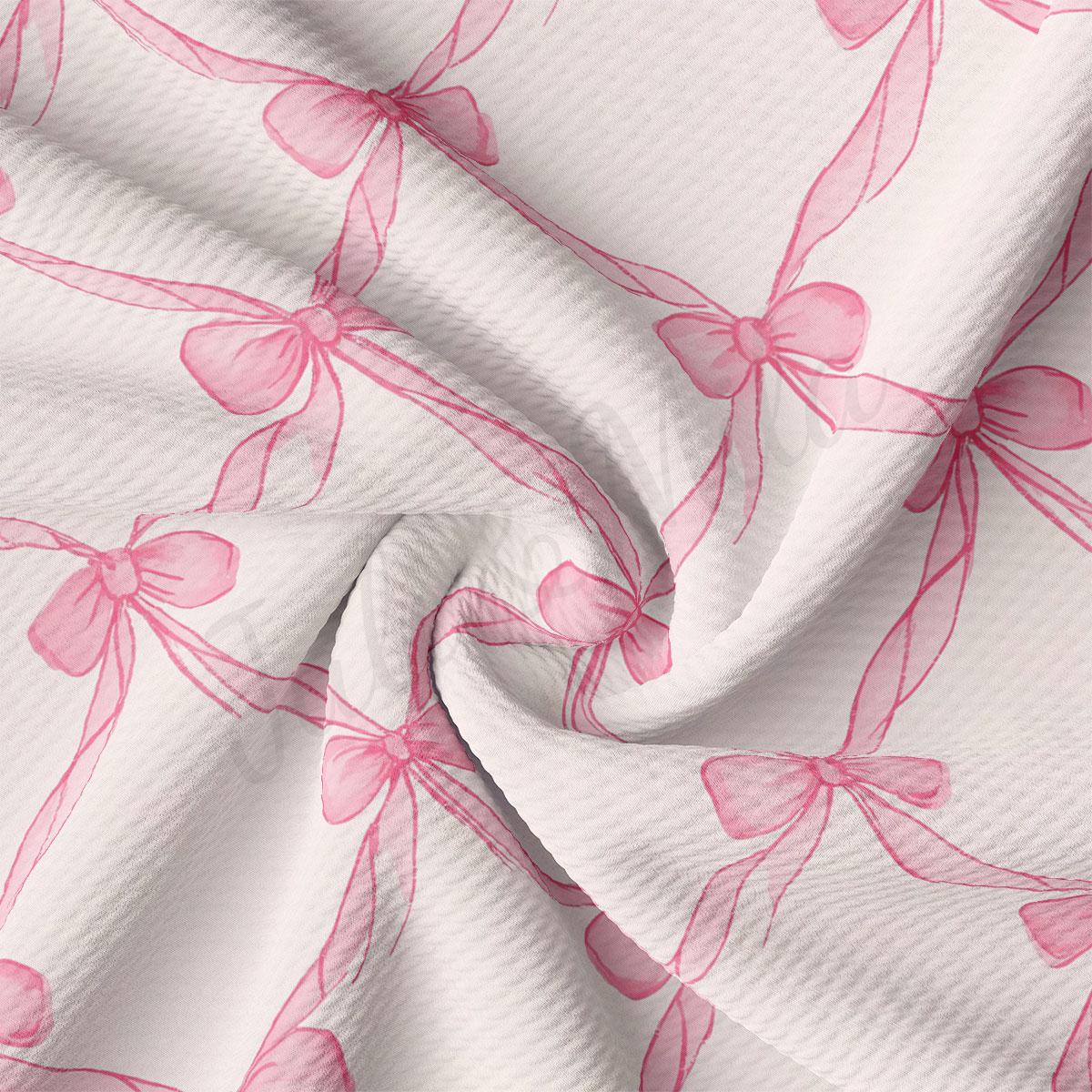 a close-up view of a fabric with a repeating pattern of pink bows on a white background.