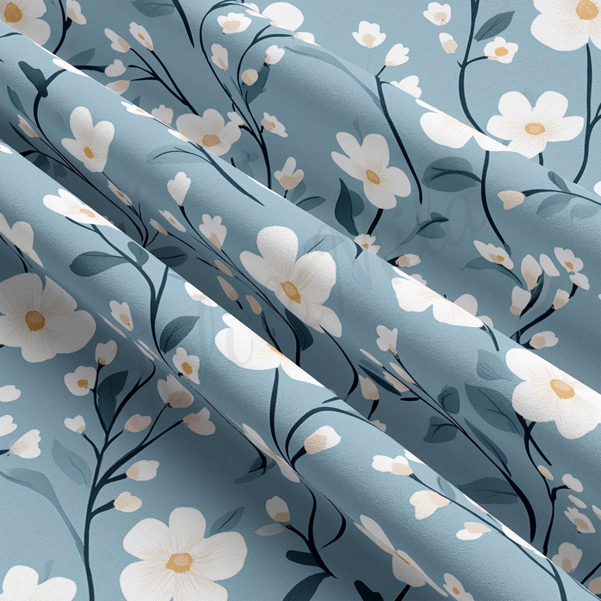 a close-up view of a fabric with a repeating floral pattern of white flowers and green leaves. The pattern is composed of multiple rows of flowers and leaves, creating a visually appealing and intricate design.