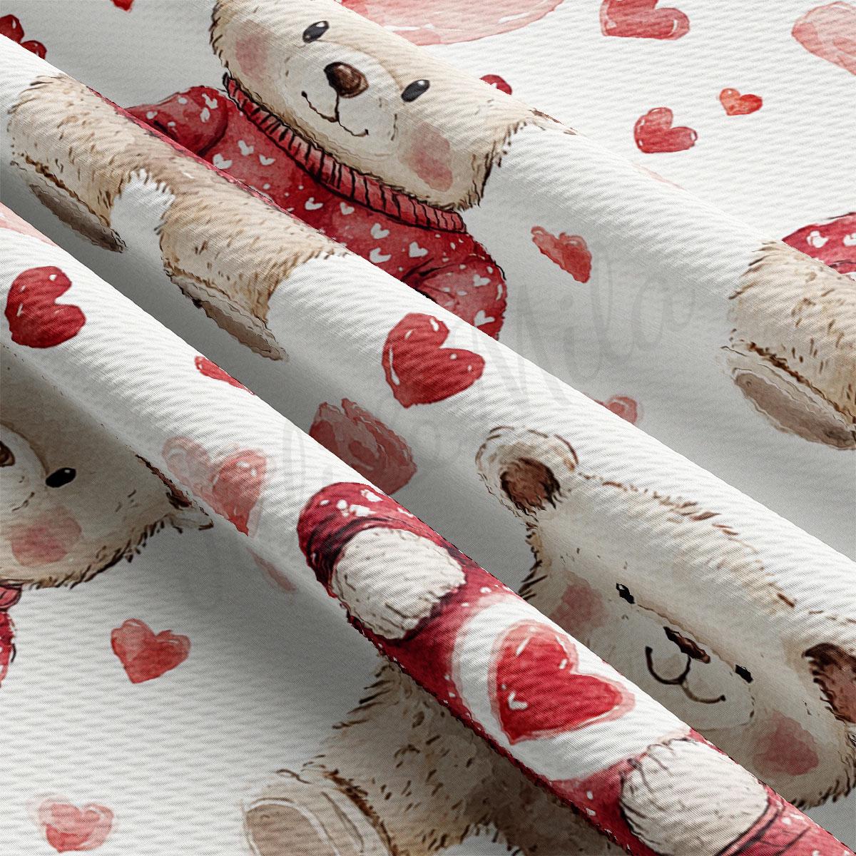 a close-up view of a fabric with a repeating pattern of teddy bears wearing red sweaters and red hearts.