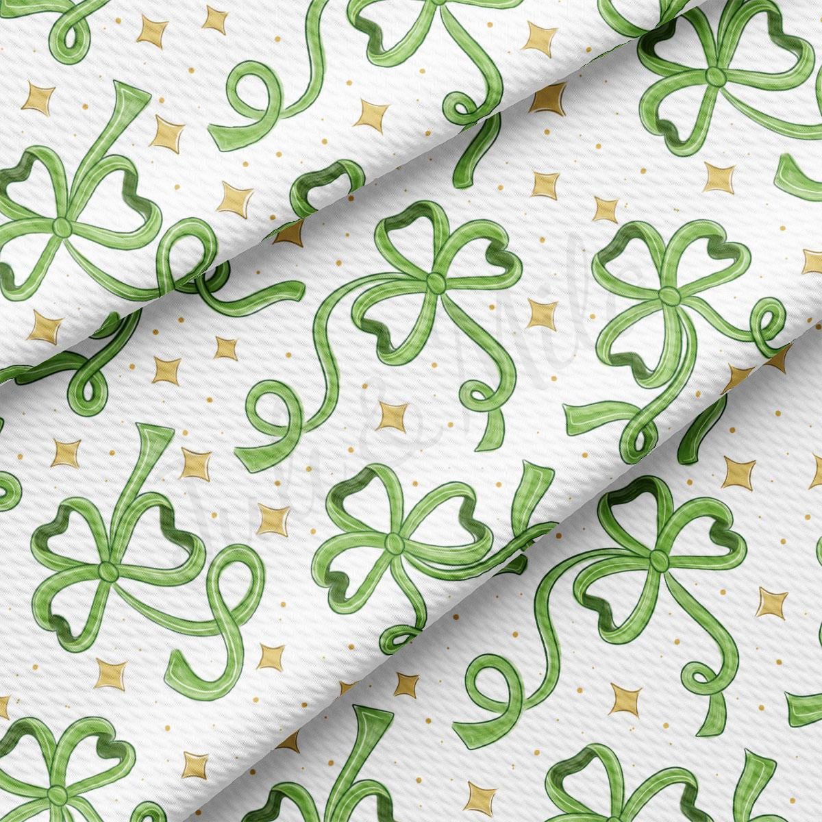 a close up of a white fabric with green ribbons