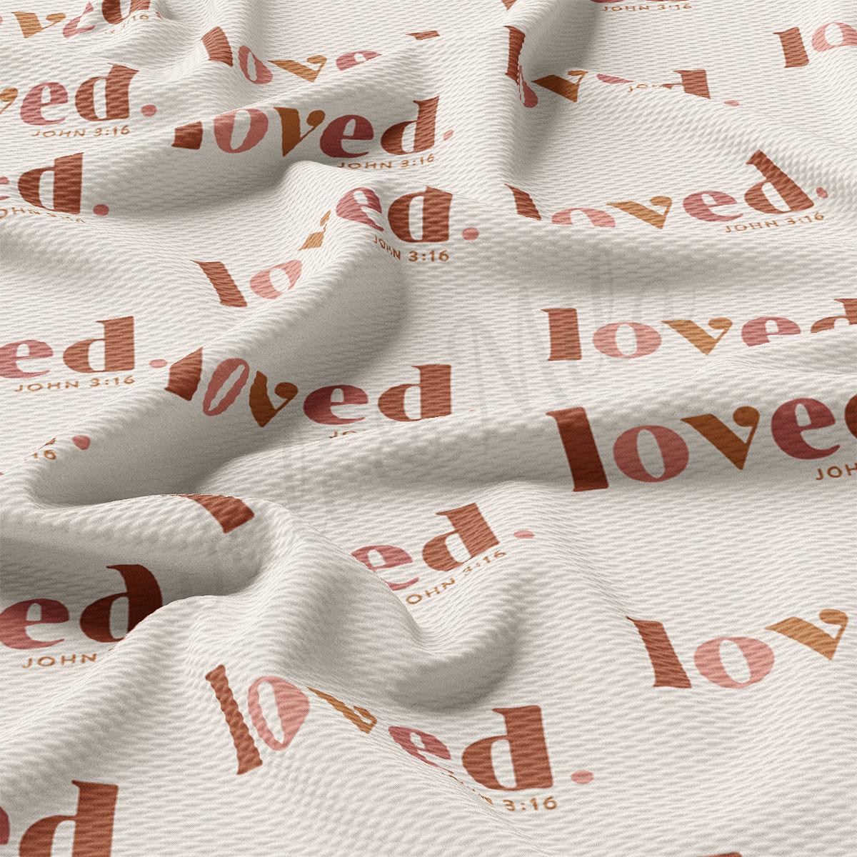 a repeating pattern of the word "loved" in various sizes and orientations, creating a visually interesting and textured fabric surface.