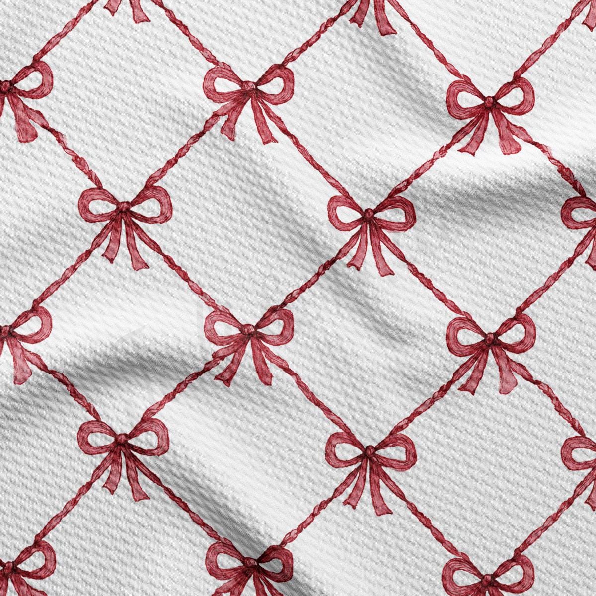 a close-up view of a fabric with a repeating pattern of red bows on a white background.