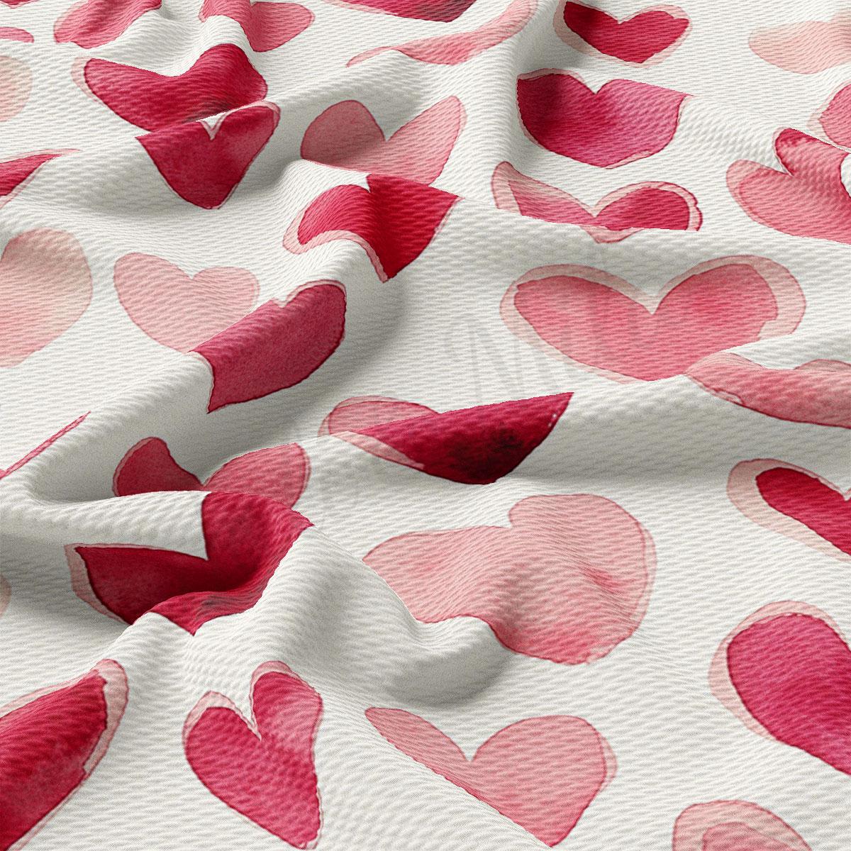 a close-up view of a fabric with a repeating pattern of pink hearts on a white background.