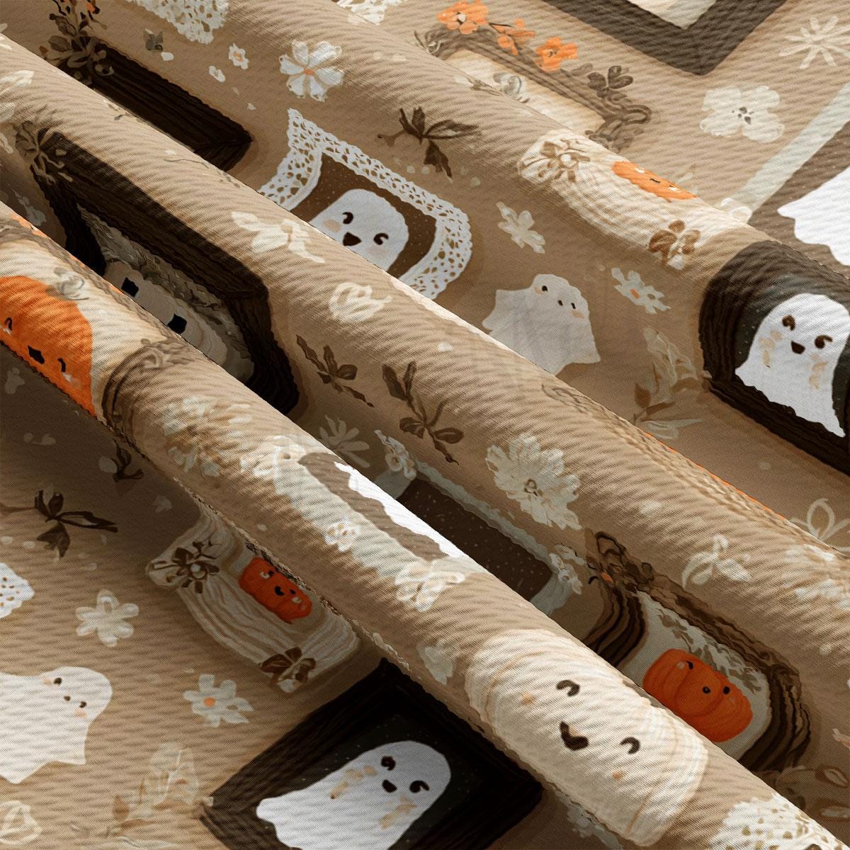 The image is a close-up of a fabric with a repeating pattern of ghost and pumpkin motifs.