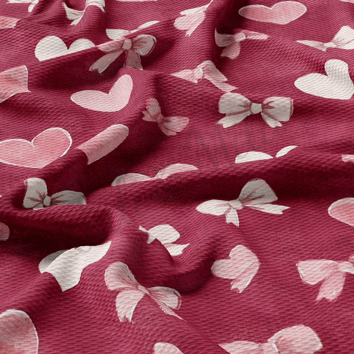a close-up view of a red fabric with white hearts and bows printed on it.
