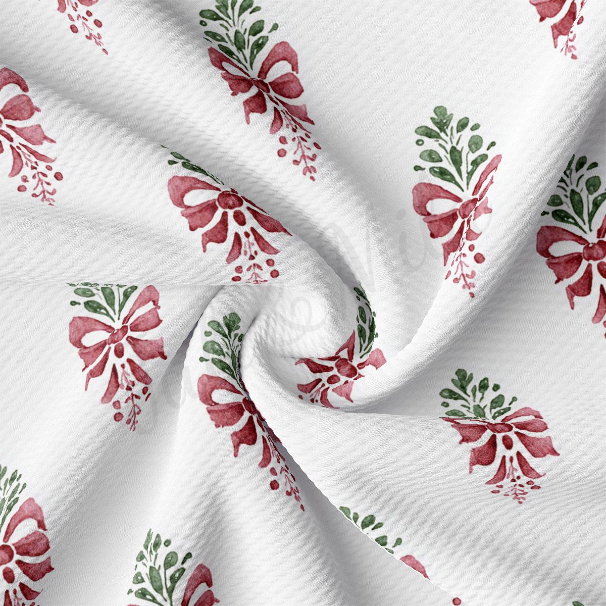a close-up view of a fabric with a repeating pattern of red bows and green leaves.