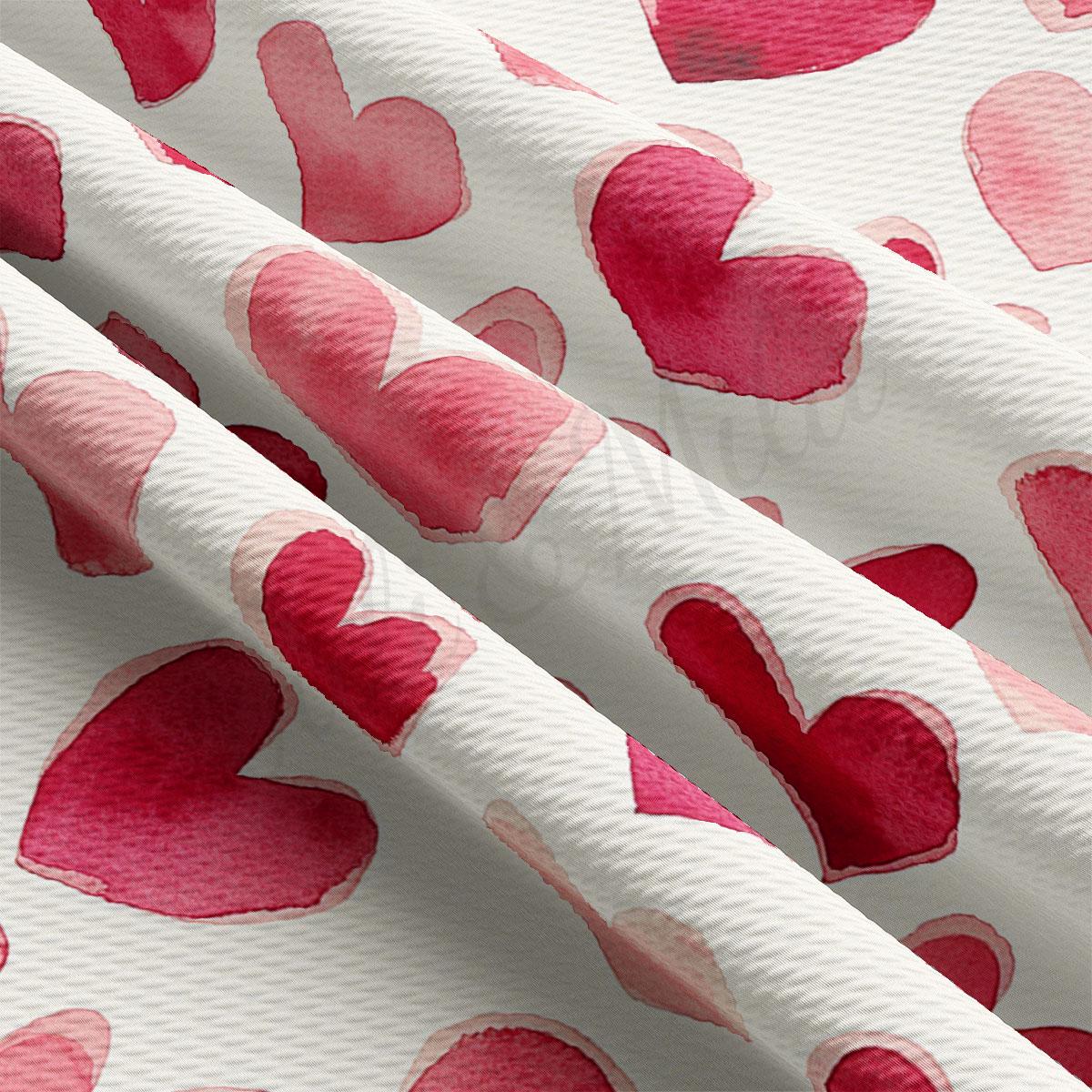 a close-up view of a fabric with a repeating pattern of pink hearts on a white background.