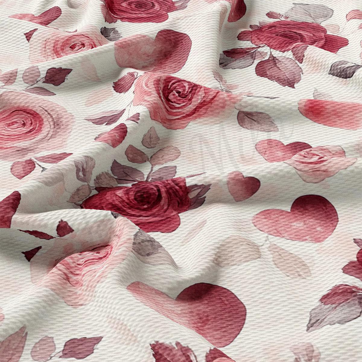 a close-up view of a fabric with a floral pattern, including red roses and hearts. The fabric appears to be wrinkled, giving it a textured and soft appearance.