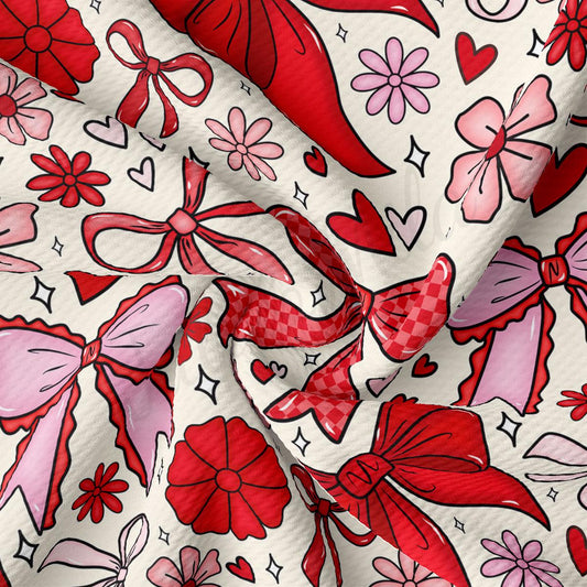 The image is a close-up of a fabric with a repeating pattern of red bows, flowers, and hearts.